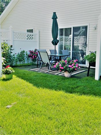 Private backyard patio with a table and chairs and flowers
